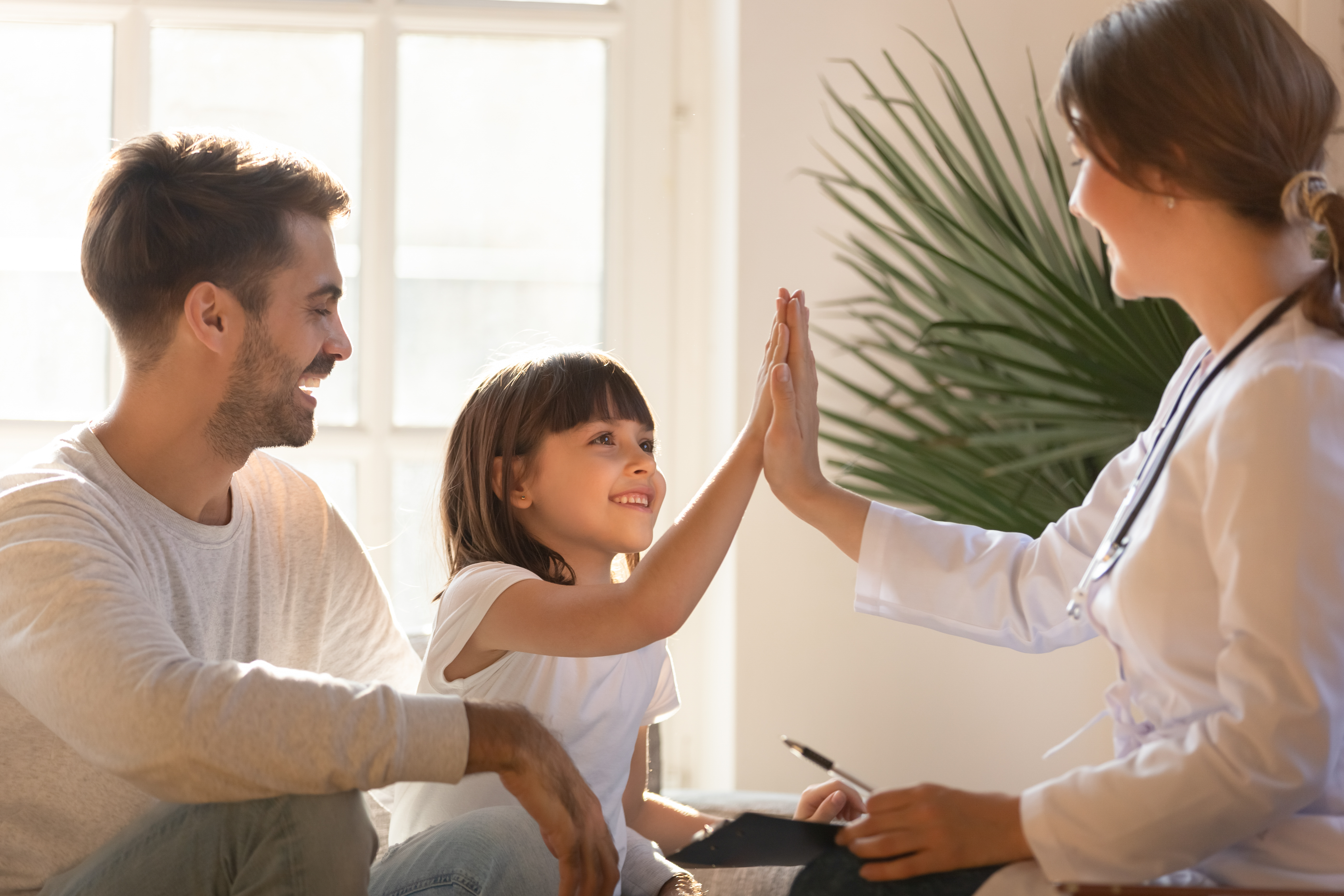 Child Girl Giving High Five To Female Caring Doctor